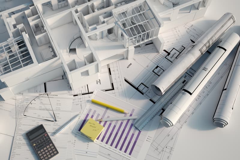 Architekturmodell mit Bauplänen – Planung einer Immobilienfinanzierung